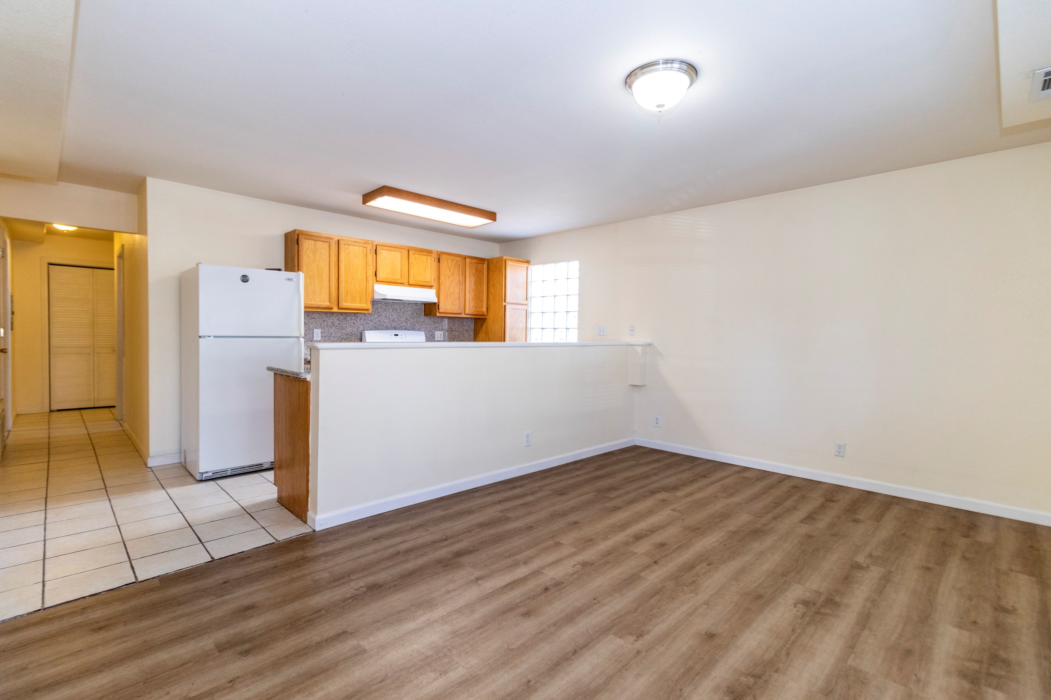 A kitchen with wooden floors and white walls.